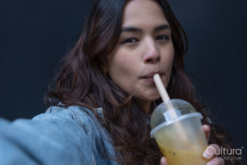 Portrait of cheerful young woman drinking bubble tea