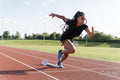 Female athlete sprinting off starting line at stadium