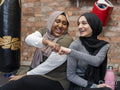 Smiling women doing fist bump in gym