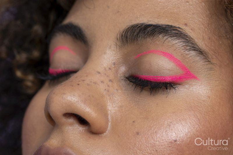 Close up of pink makeup on woman's closed eyes