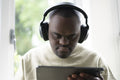 Man with Down syndrome using tablet and wearing headphones