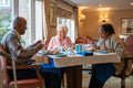 Group of seniors talking and dining at cafeteria in nursing home