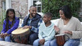 Family with children playing drums on patio