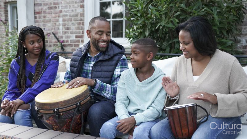 Family with children playing drums on patio