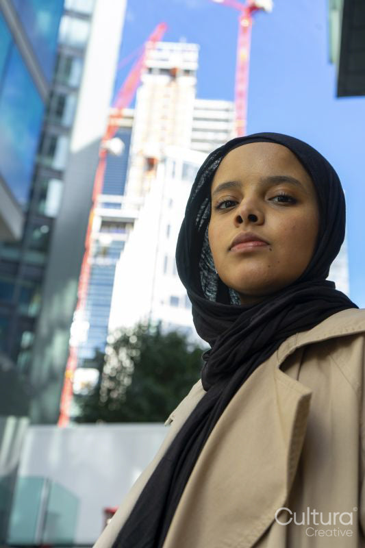 Young woman wearing hijab standing in street, portrait