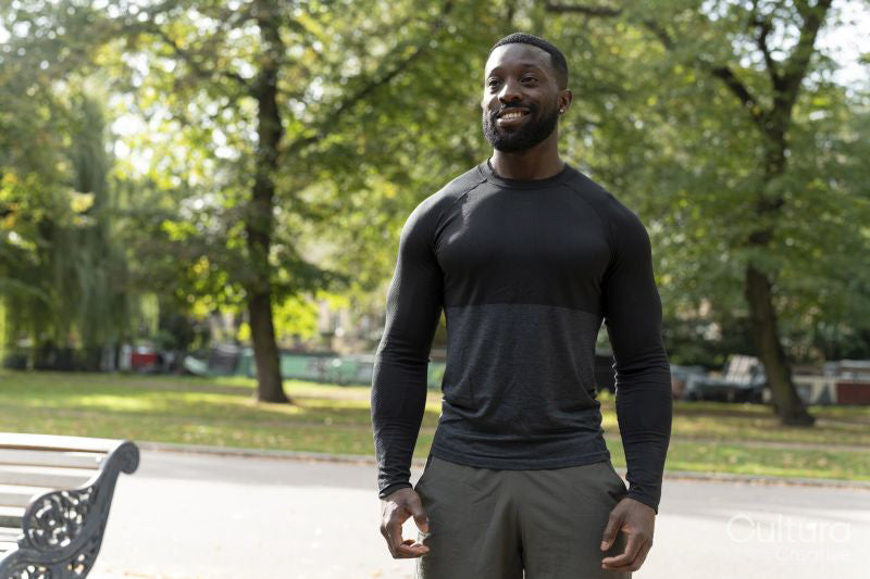 Portrait of smiling athletic man standing in park