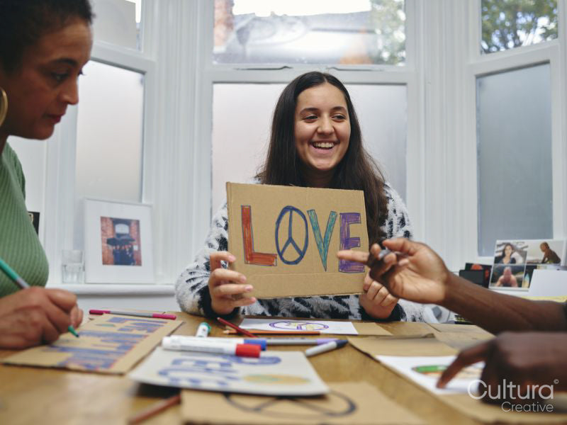 People making protest signs with symbols of peace