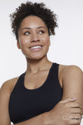 Studio portrait of smiling athletic woman in black top