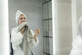 Smiling woman with towel in bathroom