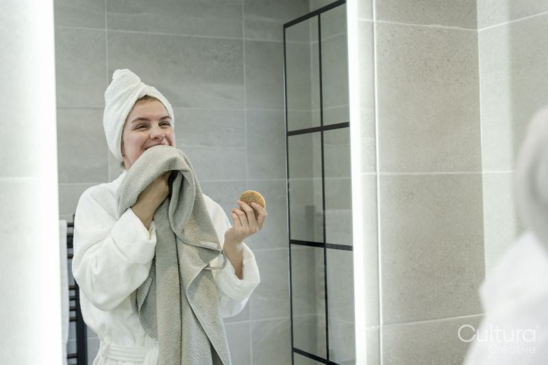 Smiling woman with towel in bathroom