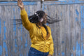 South Yorkshire, Smiling woman with braided hair and headphones dancing