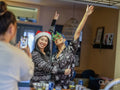 Friends taking photos in pajamas with Christmas accessories at home