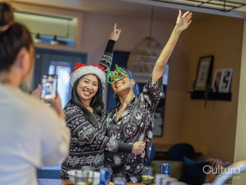 Friends taking photos in pajamas with Christmas accessories at home