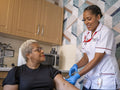 Nurse visiting mature woman at her house, preparing injection
