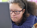 Girl with Down Syndrome using laptop at home