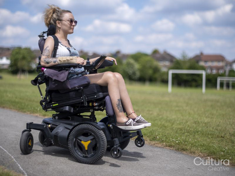 Woman in electric wheelchair going on walk