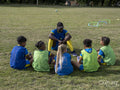 Coach giving instructions to kids on soccer field