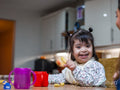 Portrait of girl with Down syndrome eating at table