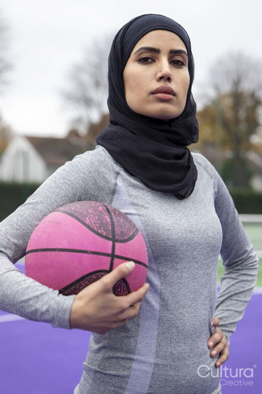 Portrait of woman in hijab holding basketball ball