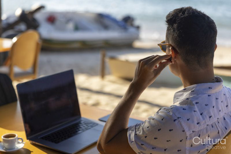 Man using laptop at beach cafe
