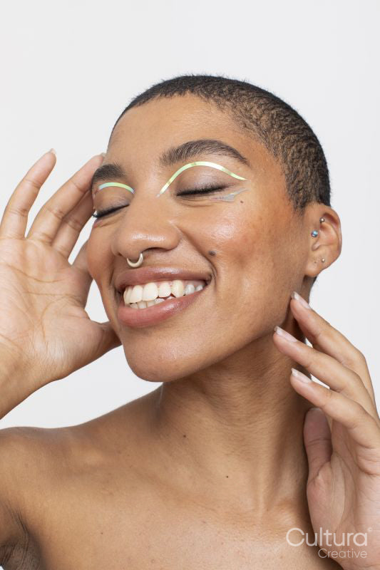 Studio portrait of smiling woman with golden foil make-up