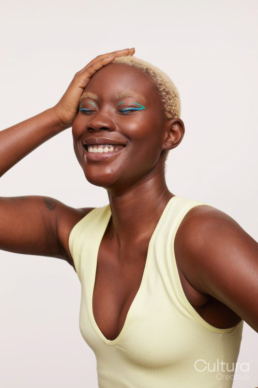 Smiling woman with closed eyes, hand on head