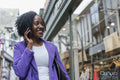 Smiling woman talking by smart phone in city