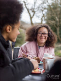 Two girls eating cakes in cafe