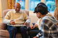 Senior man unwrapping birthday gift from daughter and grandson