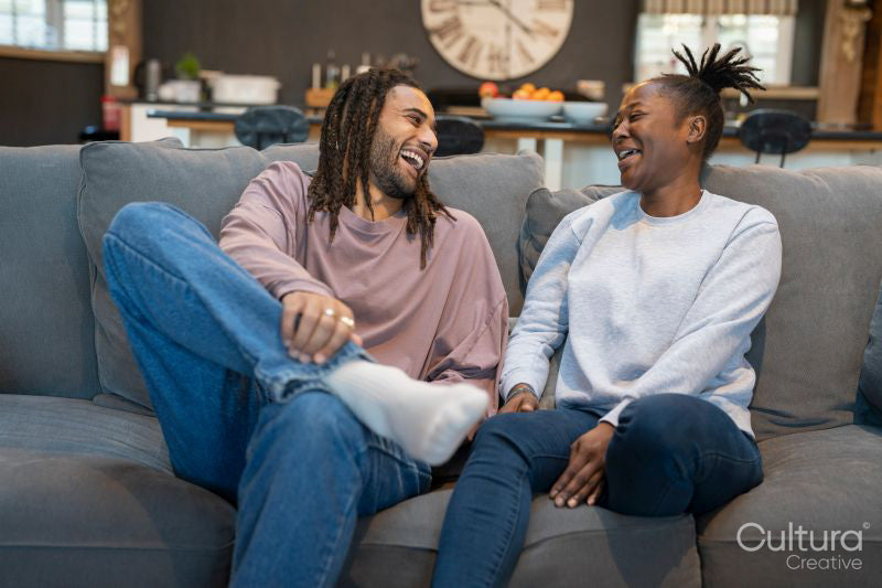 Happy couple sitting on sofa in cozy living room