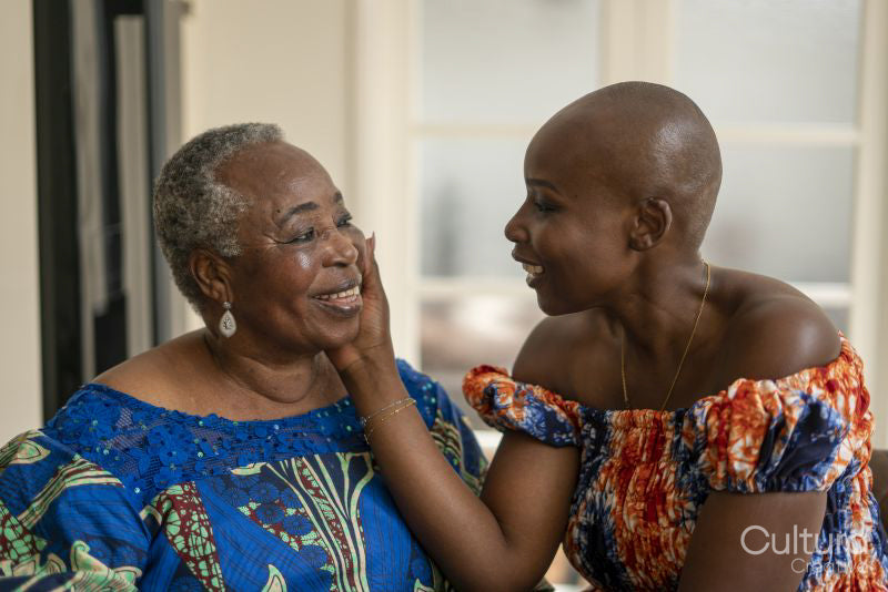 Smiling woman touching mothers face at home