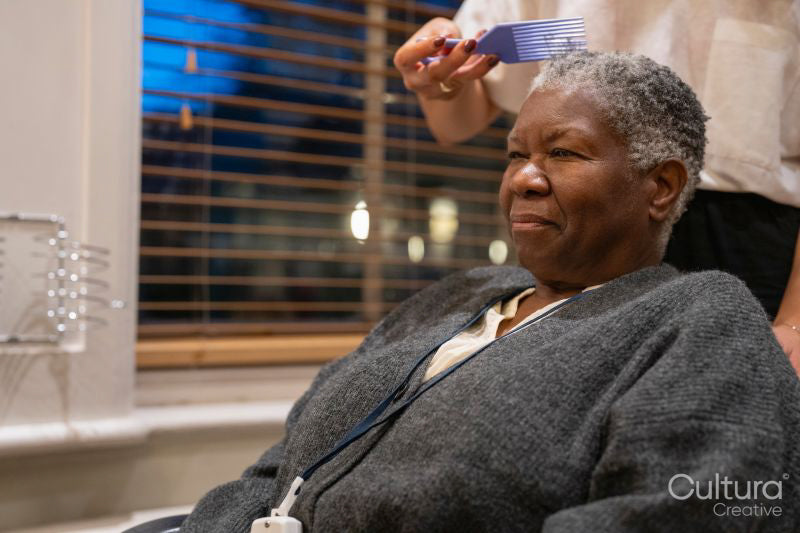 Senior woman getting hair combed in hair salon