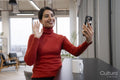 Woman waving to smart phone in office