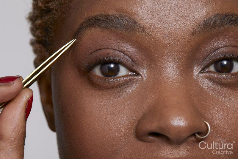 Close-up of woman with tweezers