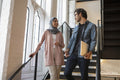 Woman wearing headscarf and man talking on steps