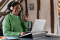 Smiling businesswoman waving during video call in office