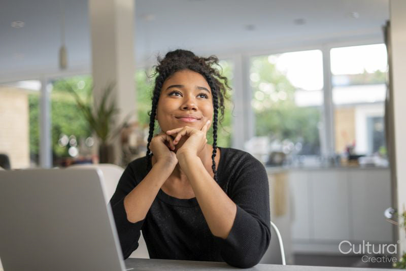 Teenage girl using laptop and thinking
