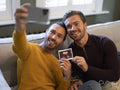 Pride couple taking selfie with ultrasound scan at home