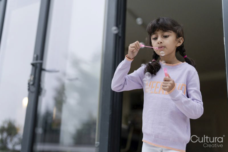 Little girls blowing soap bubbles outdoors