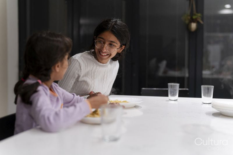 Sisters eating meal at table