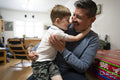 Father playing with son at home