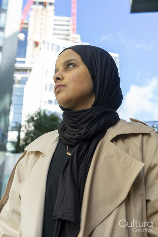 Young woman wearing hijab standing in street