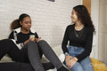 Teenage girls talking and relaxing on bed at home