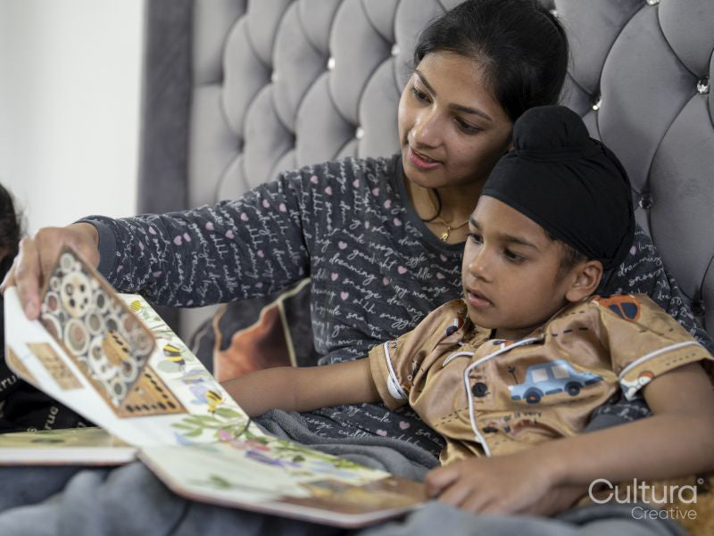 Mother and son reading book in bed