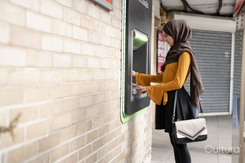 Woman in hijab using ATM