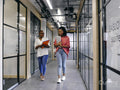 Two women walking in office hallway