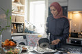 Woman in hijab preparing meal at home