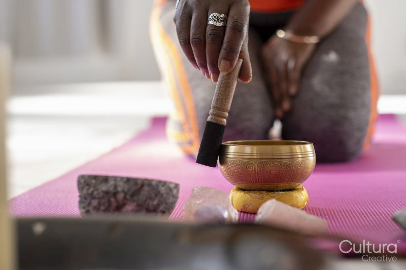Close-up of woman with singing bowl in yoga studio