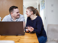 Smiling couple online shopping at home