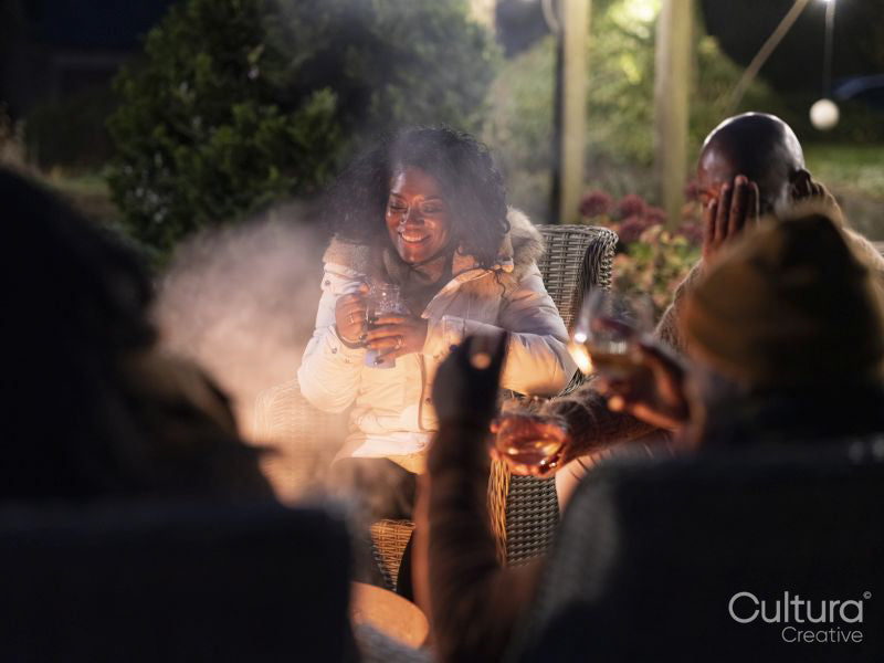 Family sitting by fire pit on patio